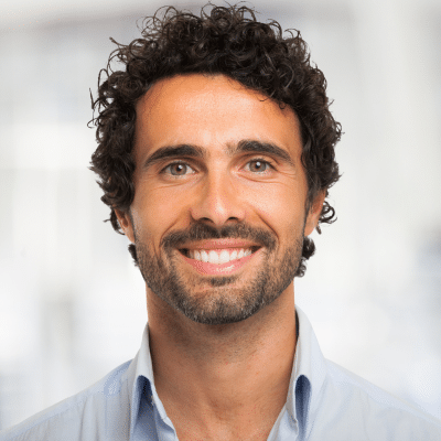 O'fallon dental works | cosmetic and general dentistry | dental care in o'fallon, mo 16 Man smiling with curly hair, representing link between genetics and oral health