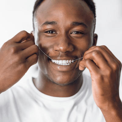 O'fallon dental works | cosmetic and general dentistry | dental care in o'fallon, mo 15 Smiling man using dental floss, representing daily oral hygiene routine